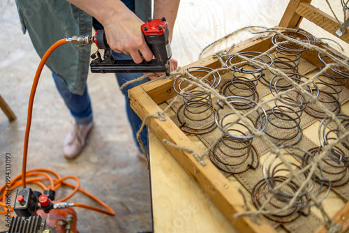 Foto Craftswoman Attaching Upholstery Springs with Staple Gun