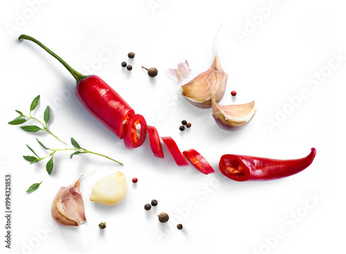 Fresh red chili pepper whole and sliced with garlic cloves, herb sprig, and peppercorns isolated on transparent background with photorealistic transparent shadow