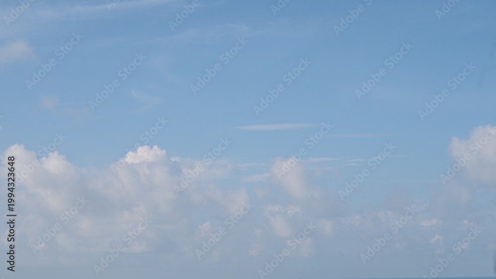 Fototapeta premium View of a bright blue sky with scattered white clouds