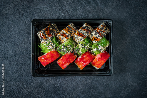 Canvastavla Colorful sushi rolls arranged artfully on a black plate with a textured backgrou
