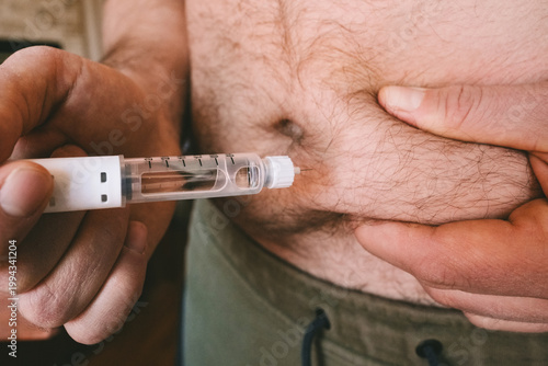 Tableau sur toile Overweight man injecting pen with GLP-1 medicine into his belly