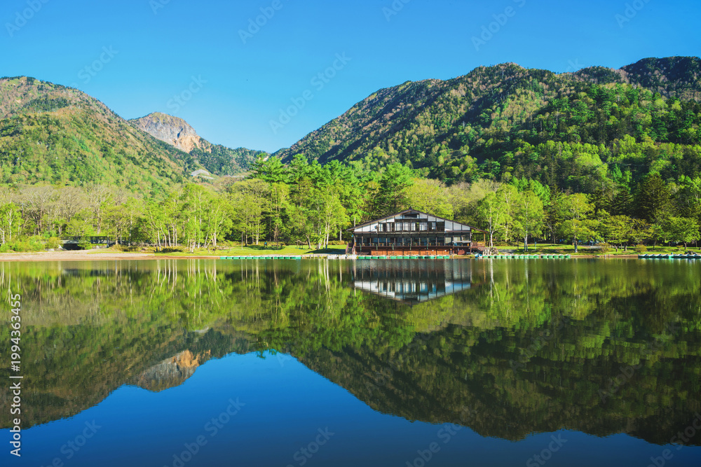 Fototapeta premium 新緑の湯ノ湖と水鏡のような水面に映った金精山と山並