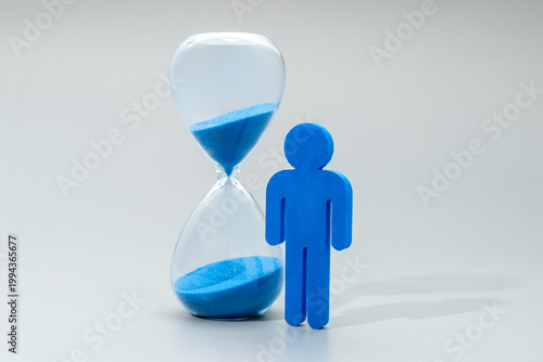 Quadro su tela A blue miniature human figure and hourglass