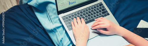 asian woman in casual wear work from home and sit on her bed for protect corona or covid-19 virus