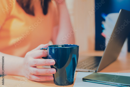 asian woman in casual wear drink coffee and work from home on her bedroom for protect corona or covid-19 virus