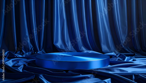 A striking studio shot showcases a circular pedestal bathed in blue light, elegantly draped with flowing blue satin curtains, creating a luxurious and dramatic presentation stage.