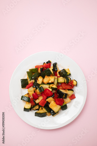 Roasted vegetables mix on white dish. Top view