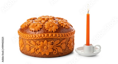 Decorative bundt cake with intricate design and a single lit candle beside it isolated on white background