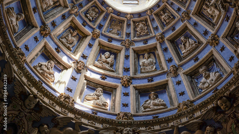 Fototapeta premium Intricate dome ceiling with sculpted figures and cherubs in a historic building