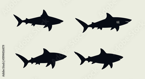 Four black shark silhouettes swimming.