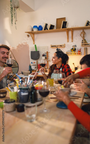 Diverse group of friends attending pottery class havng fun making clay objects together.