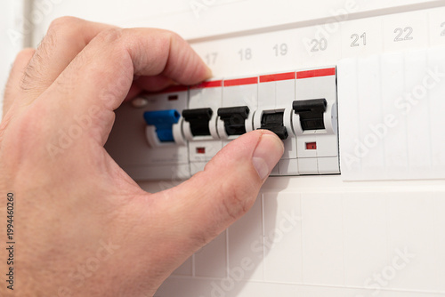 Fotografie close-up of hand interacting with an electrical circuit breaker panel in German home