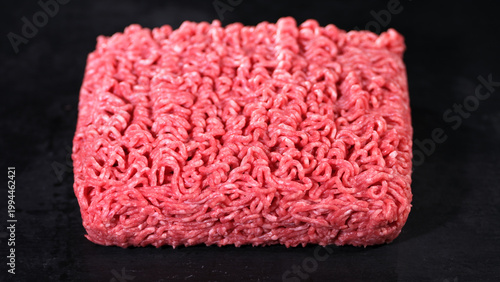 Canvastavla Ground beef is shaped into a square block on a dark surface for cooking and meal