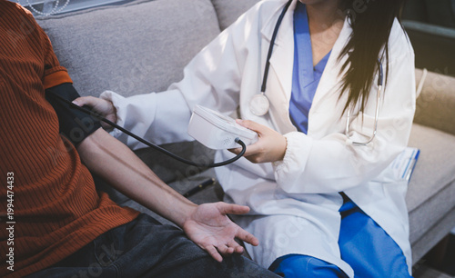 Doctor checks patient's blood pressure with cuff and stethoscope in a medical