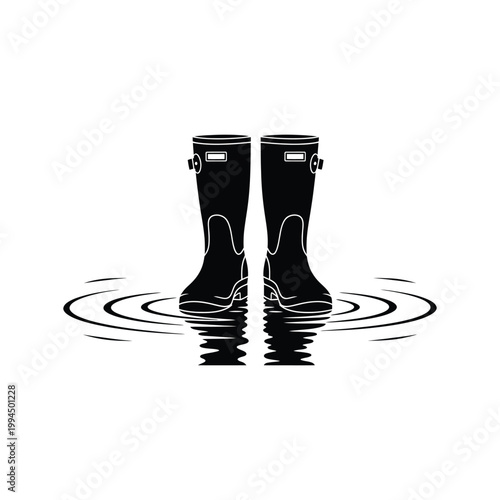 Black rain boots standing in shallow water isolated on white background