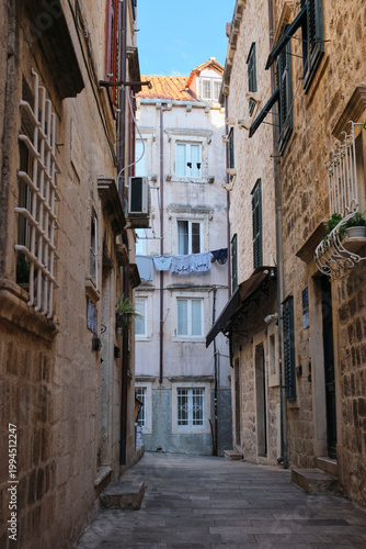 Narrow European street with weathered walls and laundry