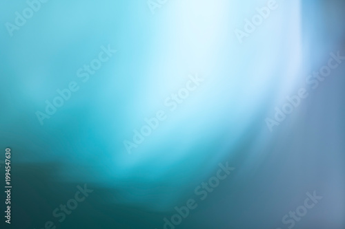 Abstract blue and teal bokeh background with soft light leaks, blurry ethereal texture with gradient motion blur for graphic design.