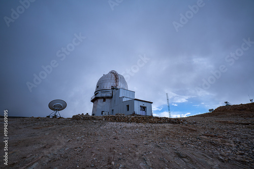 The Indian Astronomical Observatory in Hanle, Ladakh, sits under a vast blue sky, where white clouds drift by. Its setting and solitude create the perfect spot for deep space observation.