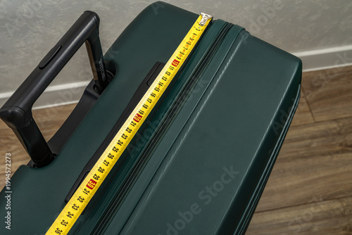 Tableau sur toile Careful checking of suitcase dimensions at the airport, measuring luggage dimens