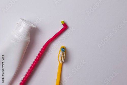 single-tuft toothbrush and regular toothbrush on a colored background, top view. High-quality oral hygiene