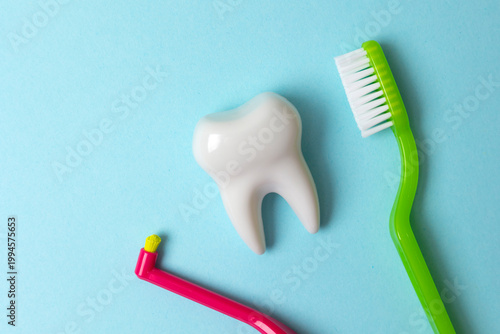 single-tuft toothbrush and regular toothbrush on a colored background, top view. High-quality oral hygiene
