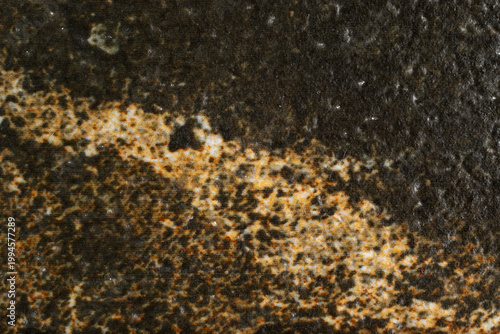 Dark marble texture with golden and white veins, natural stone surface background with grainy mineral details.