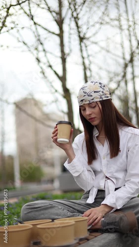 Young Woman Drinking Takeaway Coffee During Picnic In Park
