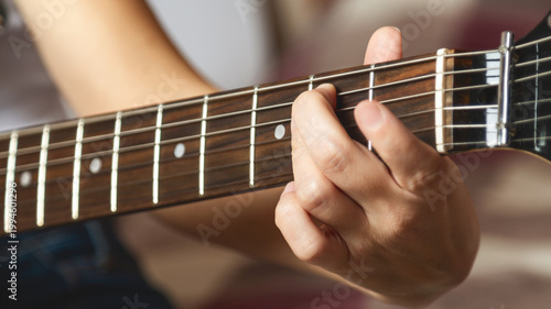 Φωτογραφία Close-up of girl's hands playing electric guitar indoors
