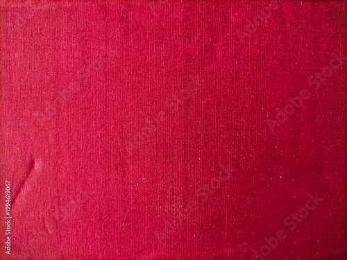 Close-up of a red cardboard surface displaying a deep, rich shade. The texture is characterized by vertical lines, giving it a distinct, tactile appearance.