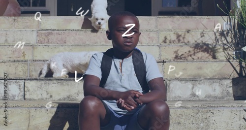 Sitting child squinting on home steps wearing light blue polo black backpack two white dogs nearby