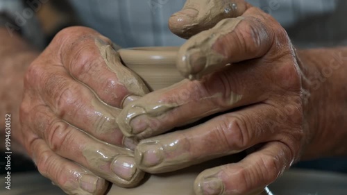 Potter's Hands Crafting Clay on a Spinning Wheel