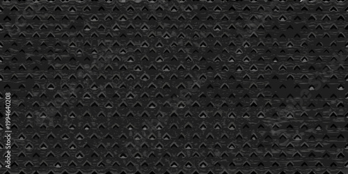 Close up of a dark textured metal surface with repeating patterns