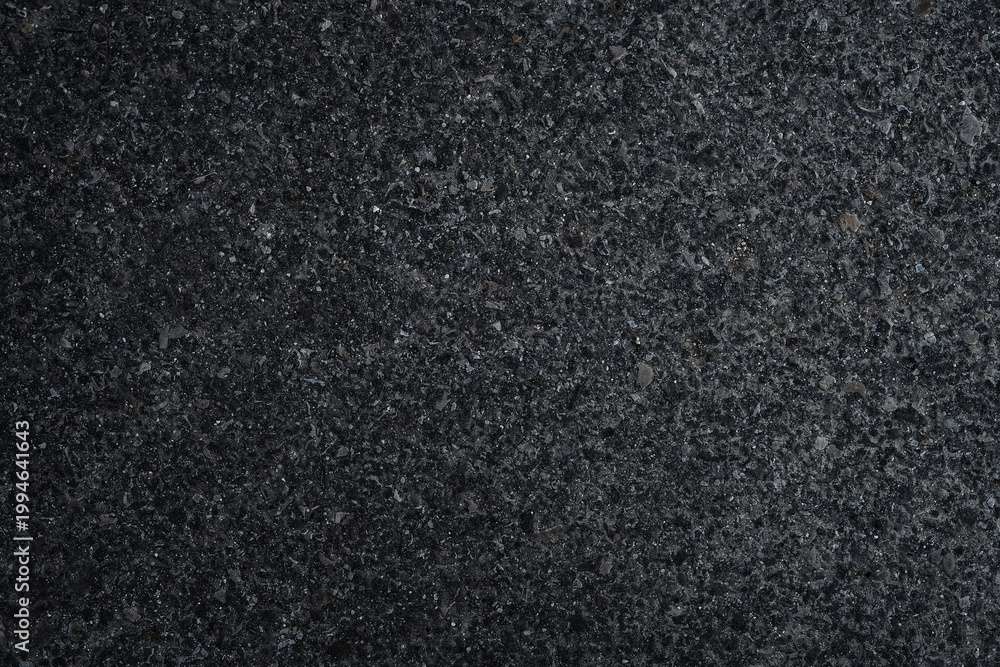 Fototapeta premium Dark asphalt or concrete surface with small stones and rough grain texture. Natural abstract background with subtle variation and industrial feel, suitable for design, overlays and construction themes