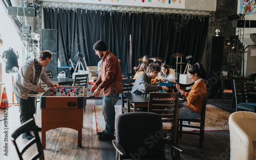 Schilderij op canvas Students play foosball and tabletop games in a casual campus lounge