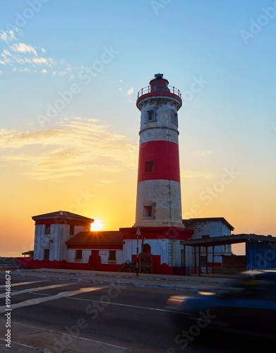 Bild auf Leinwand Jamestown lighthouse illuminates the coast, guiding ships during a vibrant sunse