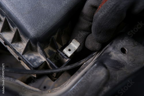 Car Air Filter Housing Clip, A mechanic's gloved hand secures a metal clip on a car's engine air filter housing