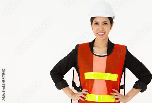 Pretty Safety Officer or Architect smiling and wearing safety vest and helmet looking forward. Highlighting her role, perhaps as a safety officer inspiration concept. isolated on white background.