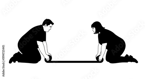 Two People Rolling a Black Rectangular Object on the Ground.