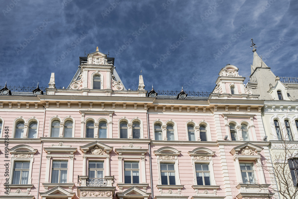 Fototapeta premium Elegant Art Nouveau facade of a historic pink building in Riga Latvia featuring ornate architectural details decorative sculptures and classical window frames