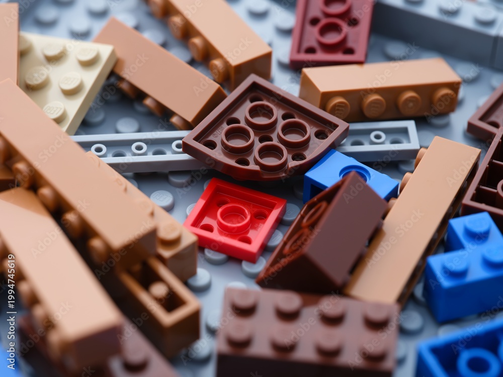 Obraz premium Tambov, Russian Federation - June 21, 2024 A close-up shot of various colorful Lego blocks scattered on a gray Lego baseplate.