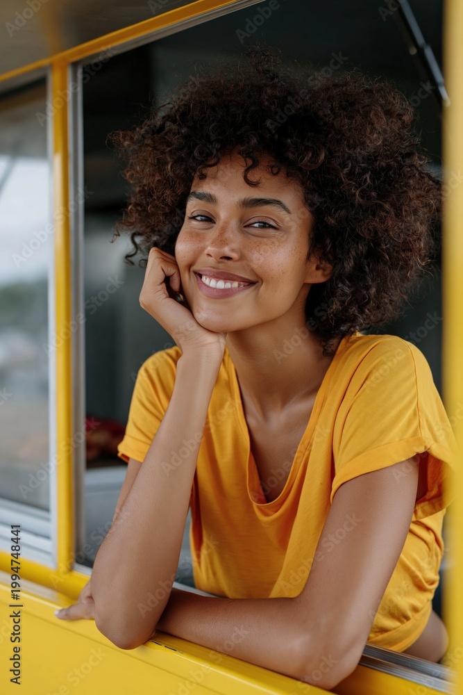 Fototapeta premium Young woman smiling and posing at yellow vehicle window
