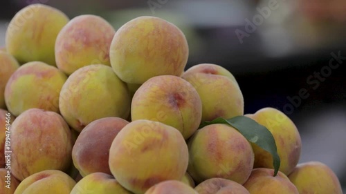 Fresh peaches displayed in a market setting, showcasing ripe fruit with natural color and texture.