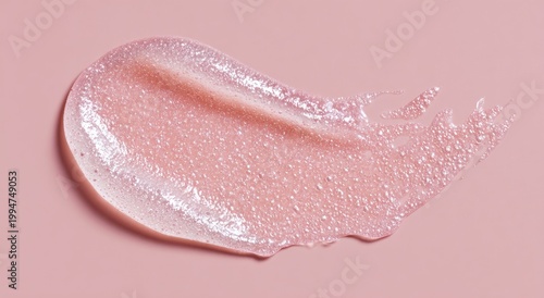 Swatch of textured, pink, cosmetic product on a smooth, matching backdrop