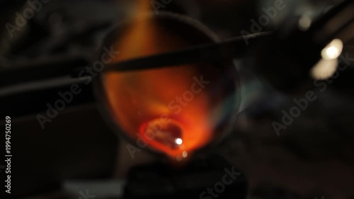 Molten gold glowing in a crucible under intense heat, captured in a close-up with vibrant orange and yellow hues.