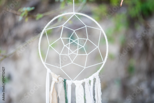 Foto White Handmade Dreamcatcher Hanging Outdoors with Soft Bokeh Nature Background