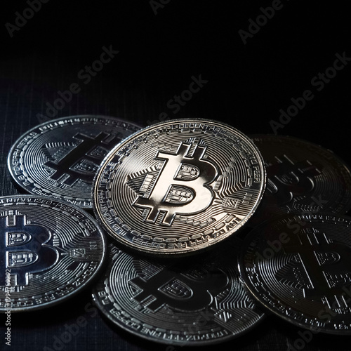 Close-up of Bitcoin cryptocurrency coin surrounded by other digital coins. Concept of blockchain technology, crypto trading, digital assets, and financial investment