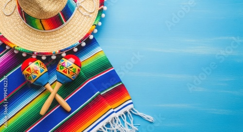 Mexican sombrero and maracas on colorful blanket