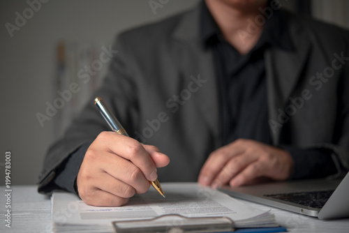 Manager signing legal document clipboard office desk pen typing laptop corporate workflow official agreement business authorization concept.