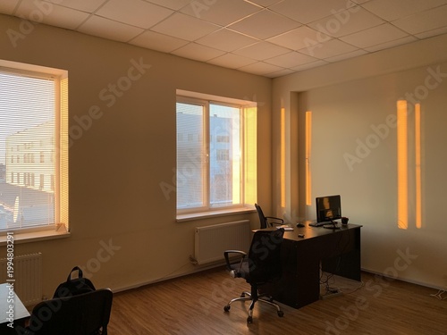 A serene office space bathed in warm sunlight, featuring a minimalistic desk and modern design elements.