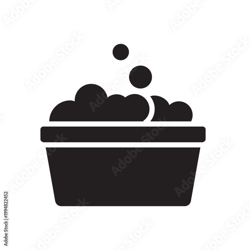 Solid vector illustration of a bucket or wash basin filled with soapy foam for cleaning.